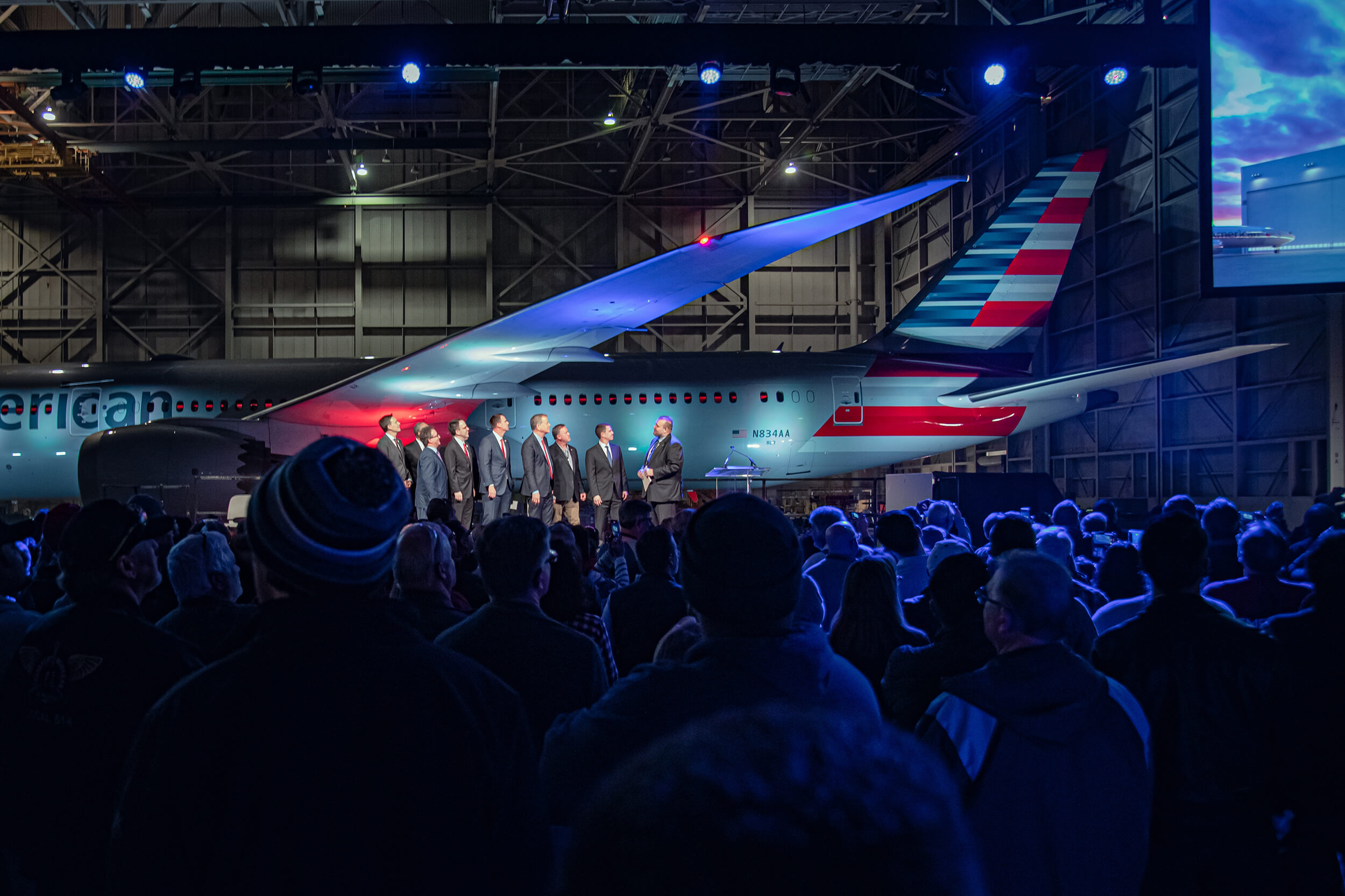 Tulsa businessmen stand in front of an American Airlines airplane during a ceremony.