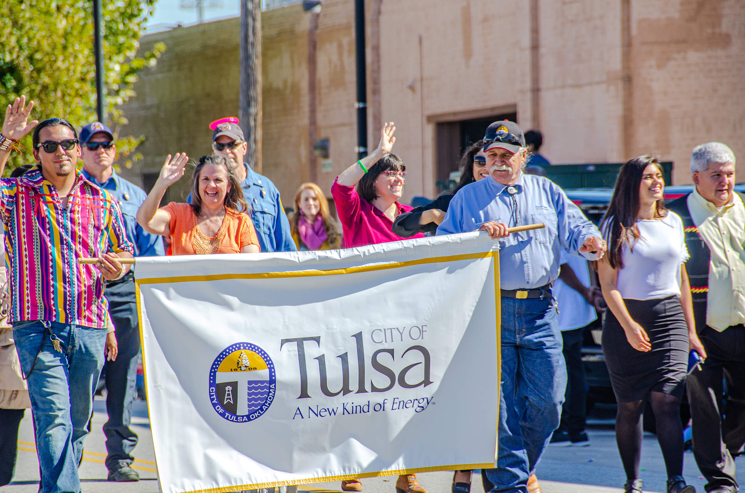 people carrying tulsa flag in a parade.